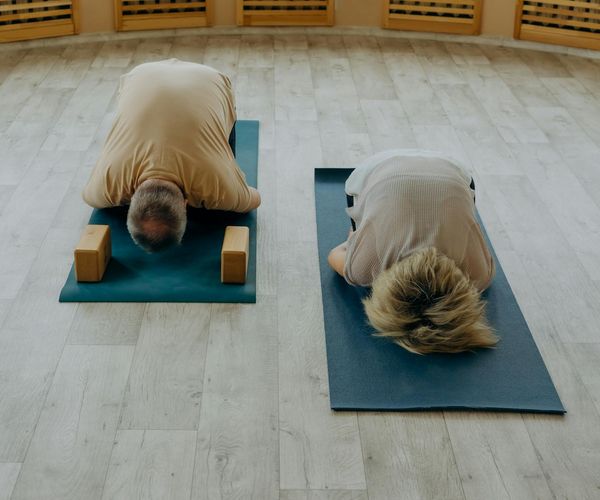 A diverse group of people practicing yoga together in a bright room.